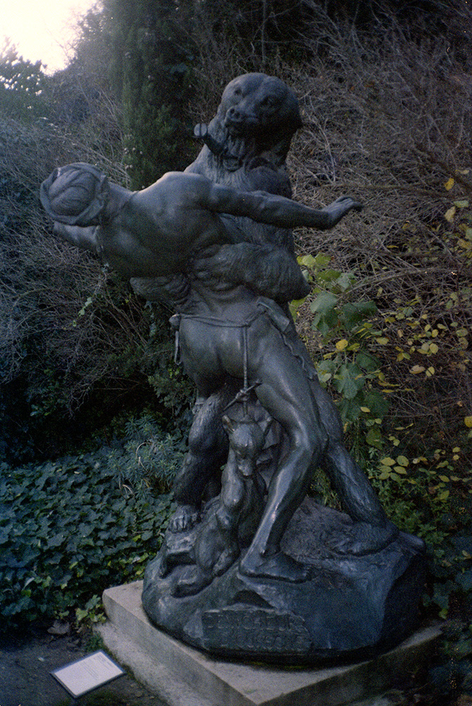 classic bronze statue of a naked man fighting a bear